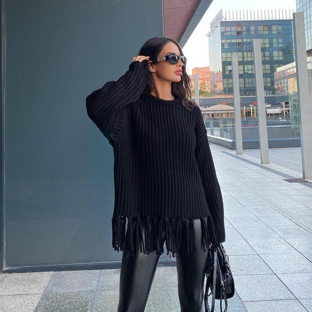 Women's oversized chunky wool pullover sweater in neutral tone with ribbed knit texture and fringe hem