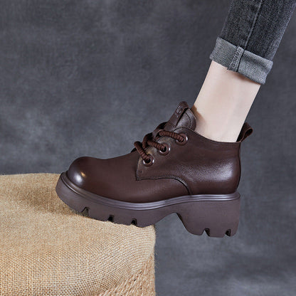 Women's genuine leather lace-up ankle boots with high shaft, thick sole, and sleek black silhouette