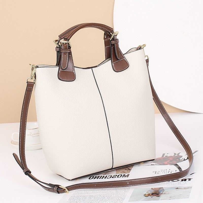 Structured black vegan leather tote bag with contrast handles and removable crossbody strap