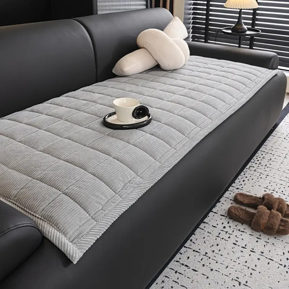 Quilted couch cover with non-slip backing in neutral tone, protective furniture layer with textured finish