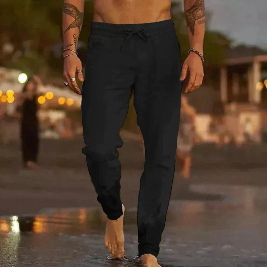 Beige tapered linen pants with elastic waistband and adjustable drawstring for relaxed beach style