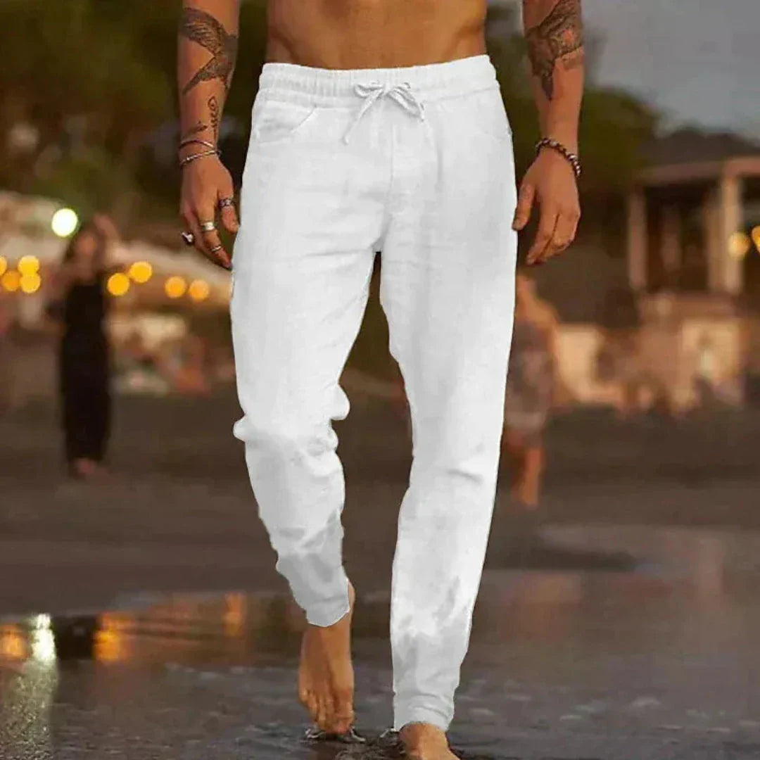 Beige tapered linen pants with elastic waistband and adjustable drawstring for relaxed beach style