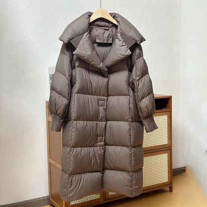 Women's oversized long puffer coat in neutral tone, warm down-filled winter outerwear with elegant silhouette