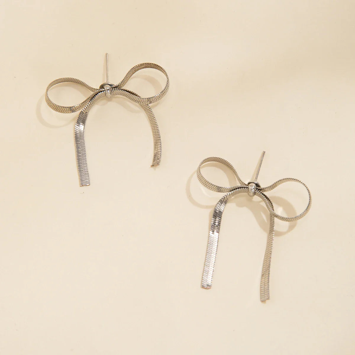 Gold silver angel bow earrings with ribbed tassels, elegant everyday jewelry symbolizing love and celebration
