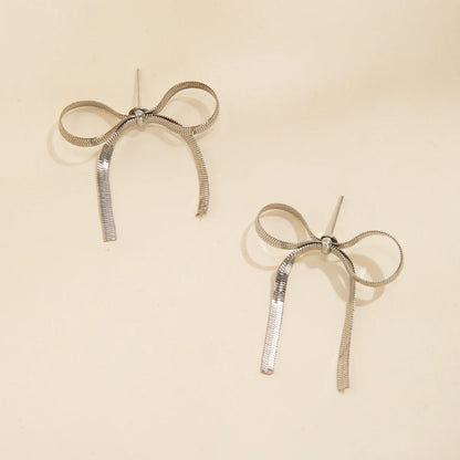 Gold silver angel bow earrings with ribbed tassels, elegant everyday jewelry symbolizing love and celebration