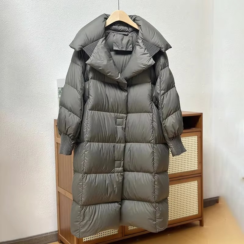 Women's oversized long puffer coat in solid color, warm down-filled winter outerwear with elegant silhouette