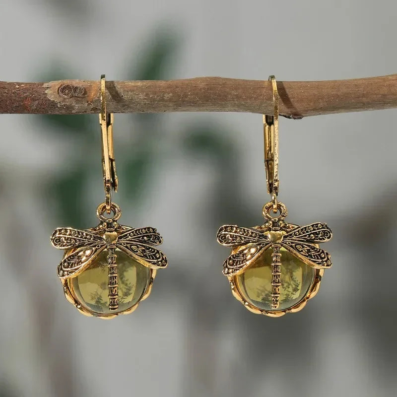 Antique gold-tone dragonfly drop earrings with pale blue crystal cabochon and carved vintage setting