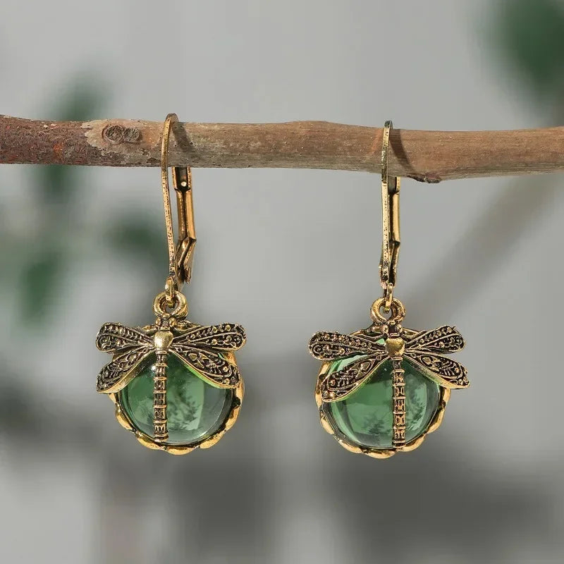 Antique gold-tone dragonfly drop earrings with pale blue crystal cabochon and carved vintage setting