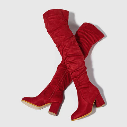 Black over-the-knee heeled boots with block heel, sleek silhouette, and elongating leg-lengthening design