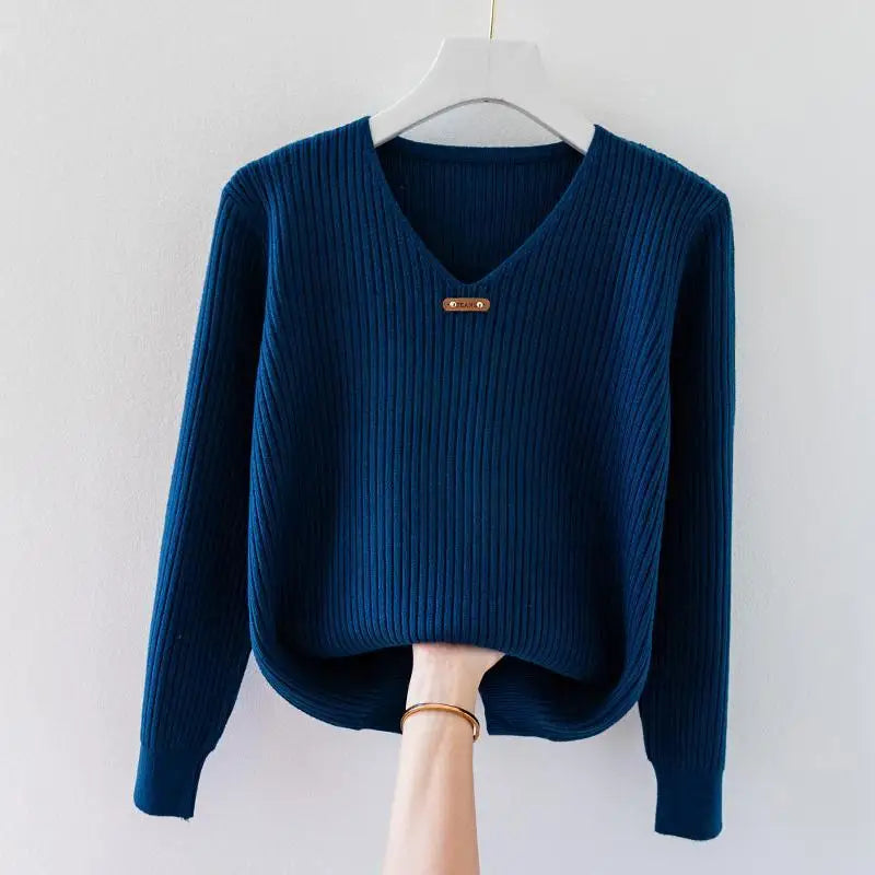 Ivory slim-fit ribbed knit pullover top with V-neckline and metal charm collar accent