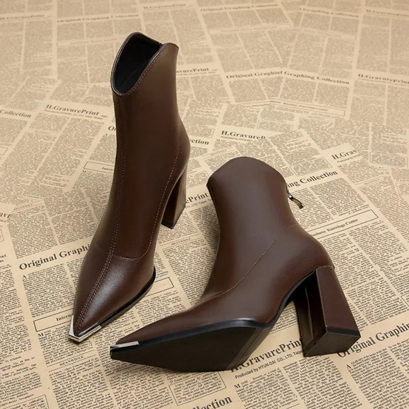 Women's dark faux leather Chelsea ankle boot with sleek silhouette and bold chrome toe tip