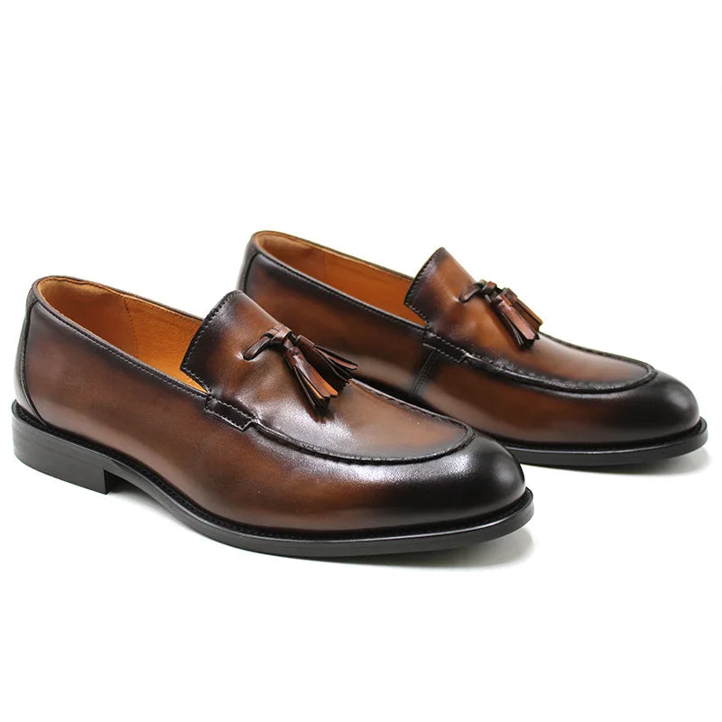 Men's black genuine leather slip-on loafer with tassel detail and sleek round-toe dress silhouette