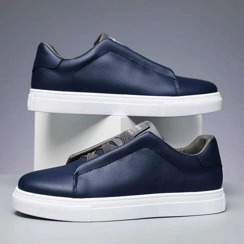 Navy faux leather low-top slip-on sneaker with thick white sole, clean minimal silhouette