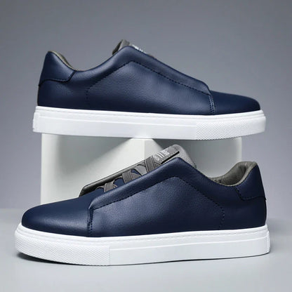 Navy faux leather low-top slip-on sneaker with thick white sole, clean minimal silhouette