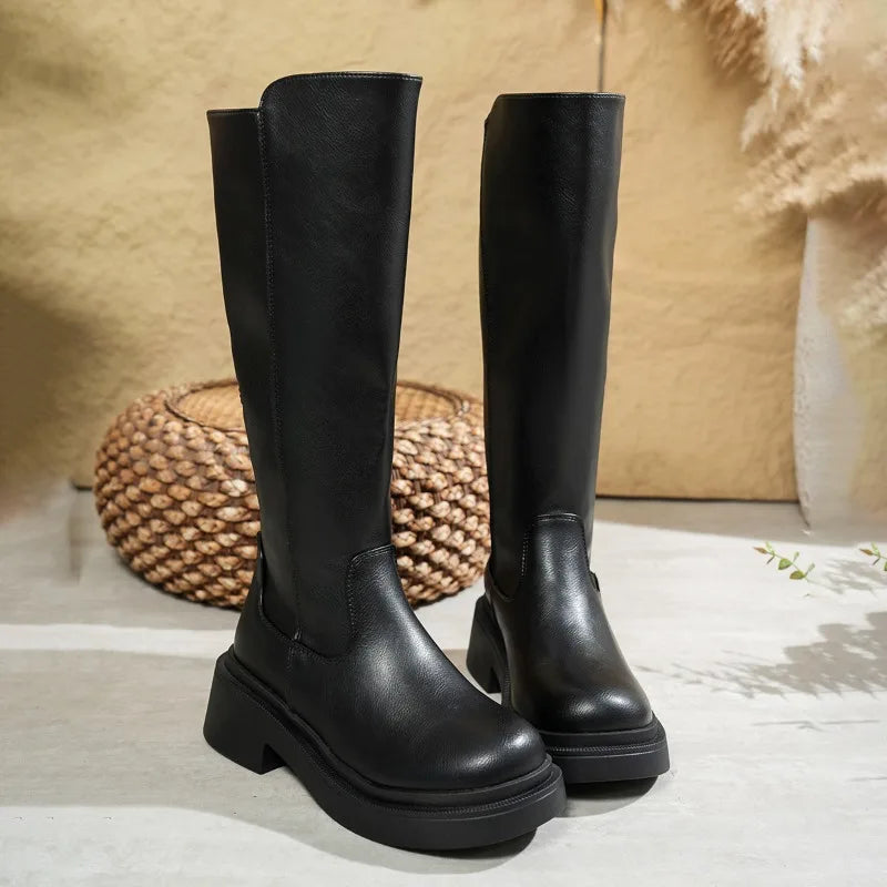 Women's black leather knee-high boots with stable block heel and sleek streamlined shaft silhouette