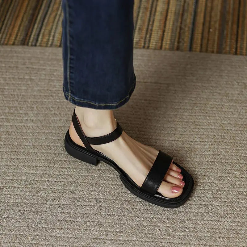 Women's slip-on sandals in neutral tone with cushioned sole and minimalist buckle accent detail