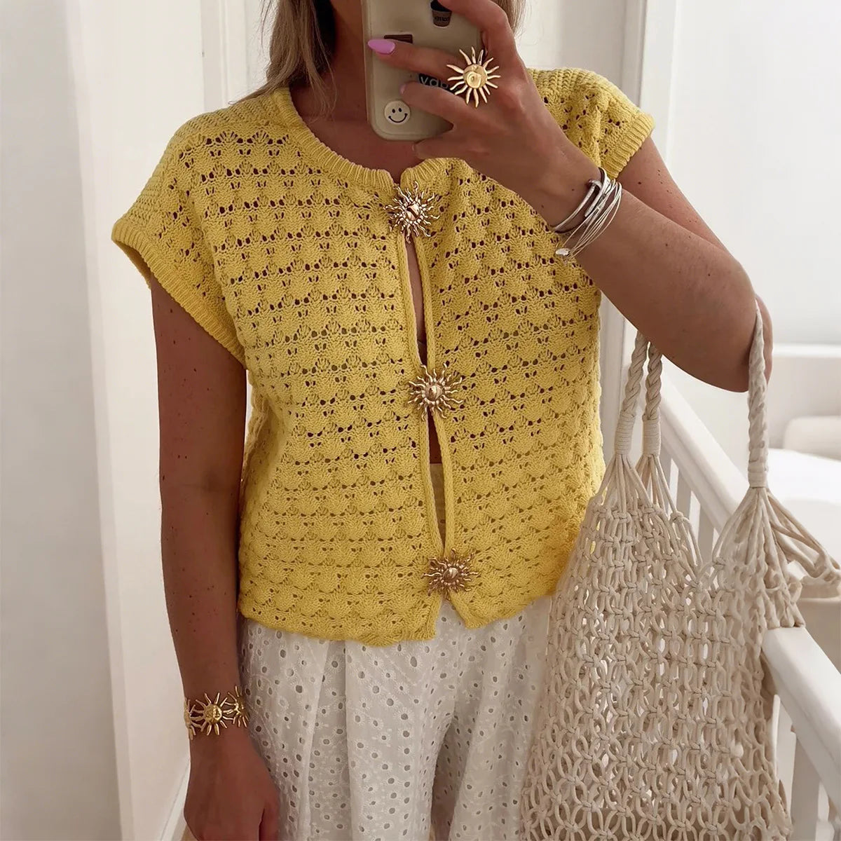 White cropped crochet knit top with floral button accents and relaxed fit for spring summer