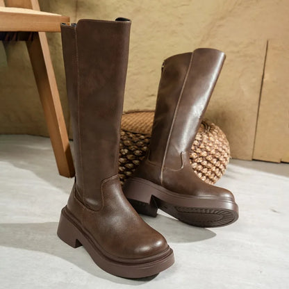 Women's black leather knee-high boots with stable block heel and sleek streamlined shaft silhouette