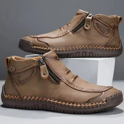 Men's brown full-grain leather boots with hand-stitched detailing and side zip closure