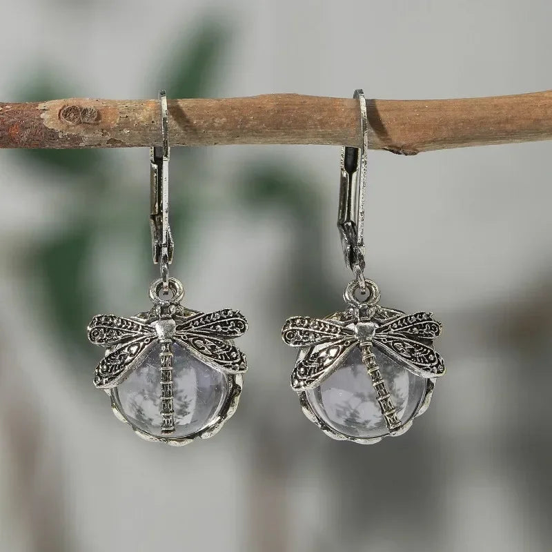 Antique gold-tone dragonfly drop earrings with pale blue crystal cabochon and carved vintage setting