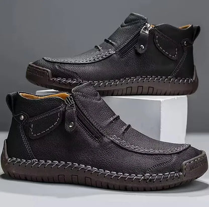 Men's brown leather boots with hand-stitched detailing, cushioned sole, and side zip closure