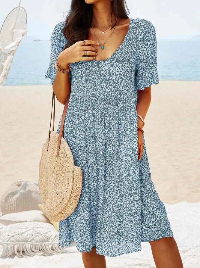Women's navy ditsy floral smock dress with V-neck, flutter sleeves, smocked bodice, and tiered flowy hem