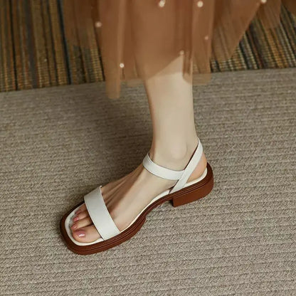 Women's slip-on sandals in neutral tone with cushioned sole and minimalist buckle accent detail