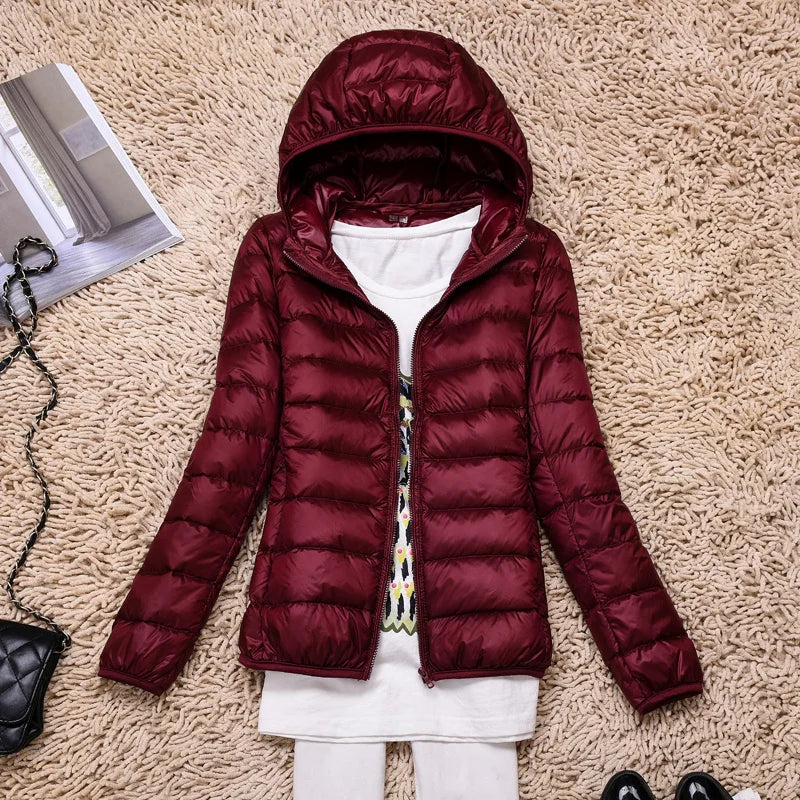 Women's quilted down jacket tailored hip-length fit with hood, lightweight warmth in neutral tone