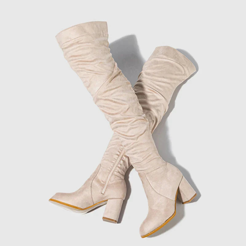 Black over-the-knee heeled boots with block heel, sleek silhouette, and elongating leg-lengthening design