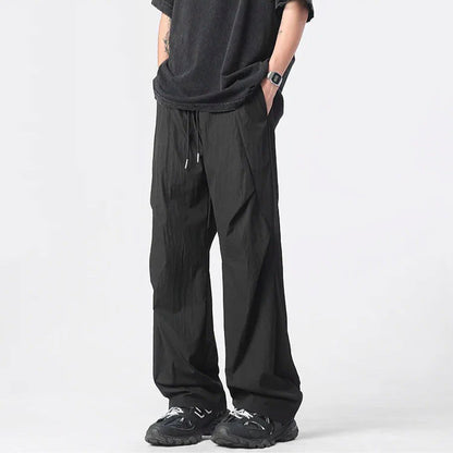 Neutral tufted parachute pants wide-leg relaxed fit with chrome-tip drawstrings lightweight nylon