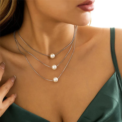 Minimalist pearl accent snake chain necklace with high-shine finish and delicate pendant for effortless styling