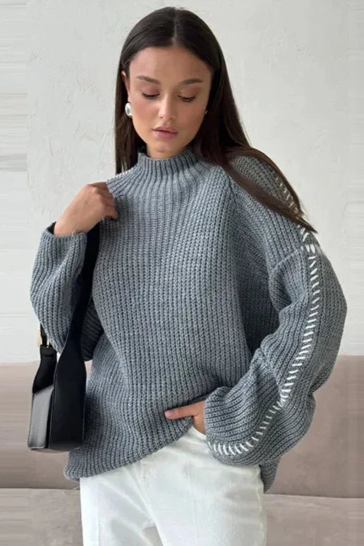 Oversized patchwork knit jumper in bold color contrasts with mock neck and flared sleeves
