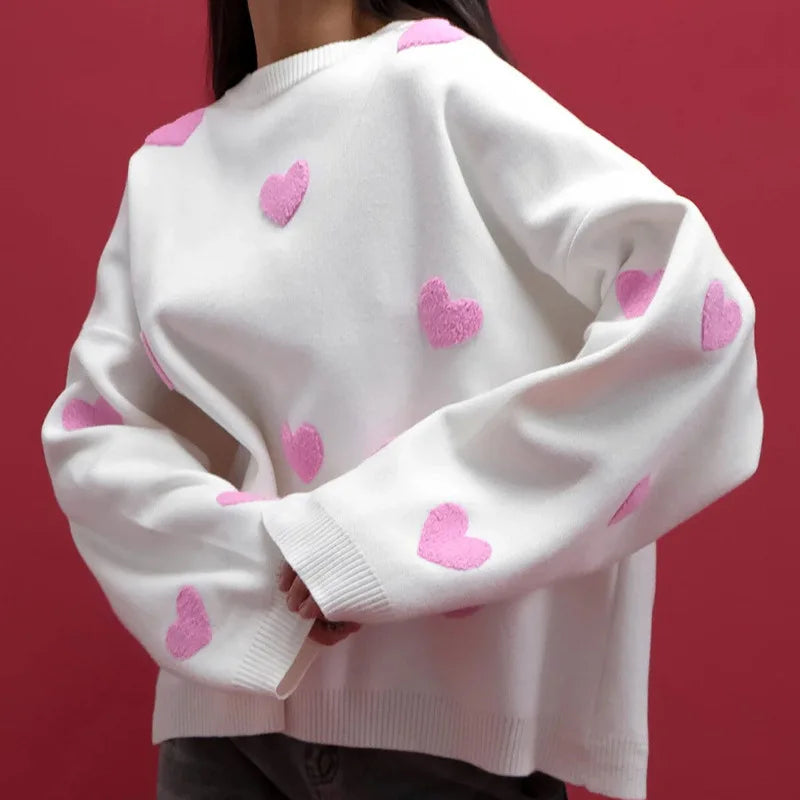 Pink women's heart print knit sweater with delicate embroidered accents and feminine relaxed fit