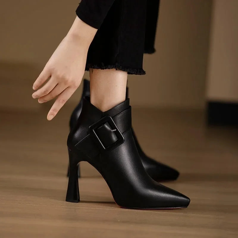 Black buckle heel boots with sleek silhouette and statement metal buckle accents