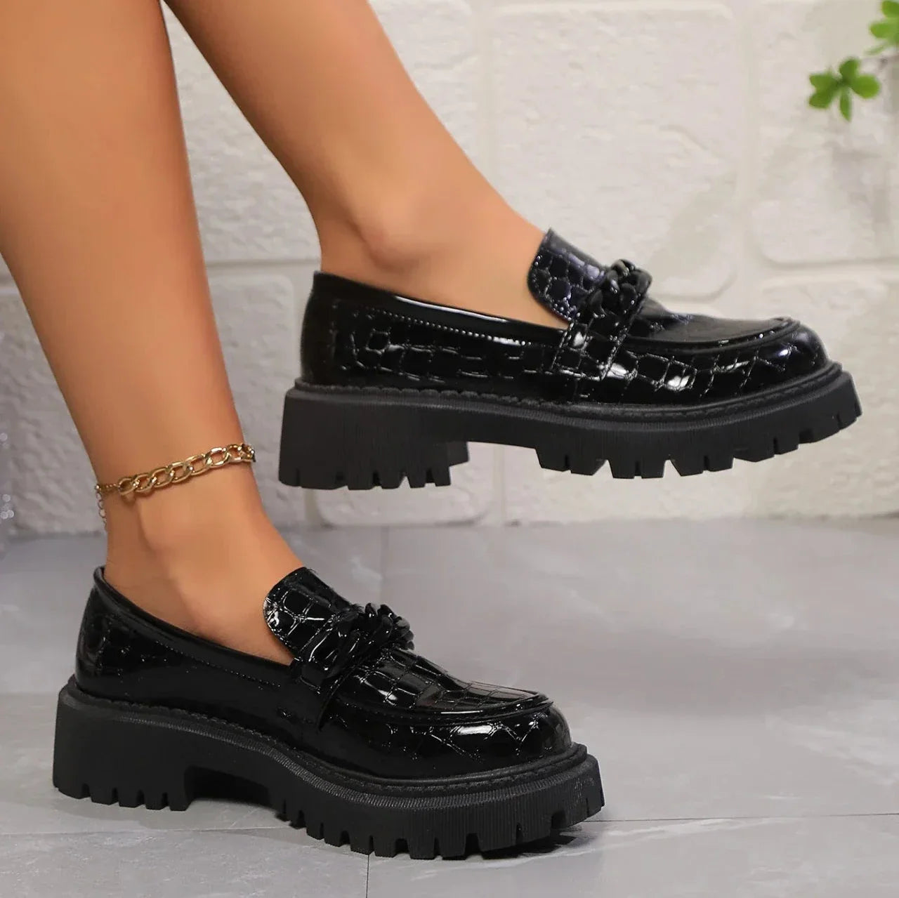 Black croc-embossed platform loafers with satin-gloss finish and chunky sole for elevated style