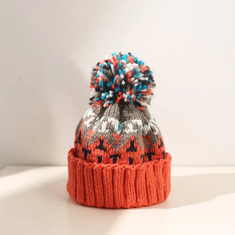 Cozy knit beanie with snowflake pattern and fluffy pom in festive winter holiday style