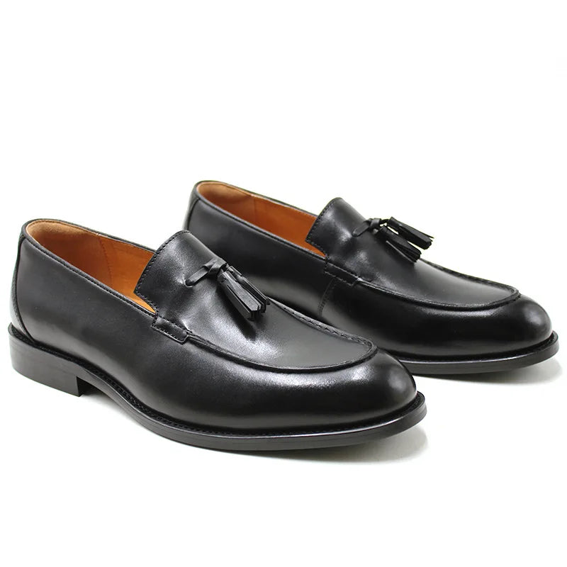 Men's black genuine leather slip-on loafers with tassel detail and sleek round-toe silhouette