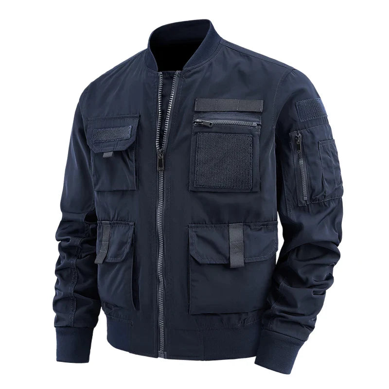 Men's olive green utility jacket with multi-pocket velcro design, zippered storage, and rugged outdoor styling