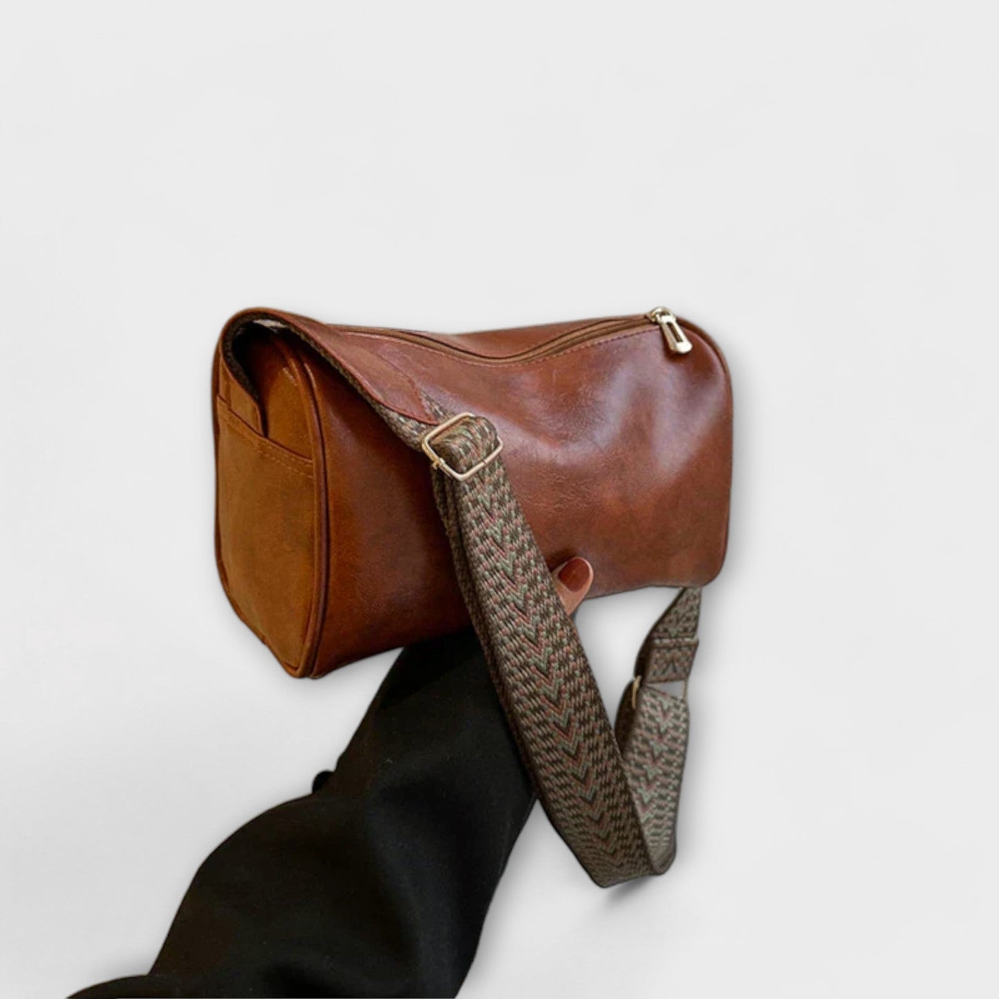 Beige woven shoulder bag with wide braided strap, spacious cylindrical shape for modern urban style