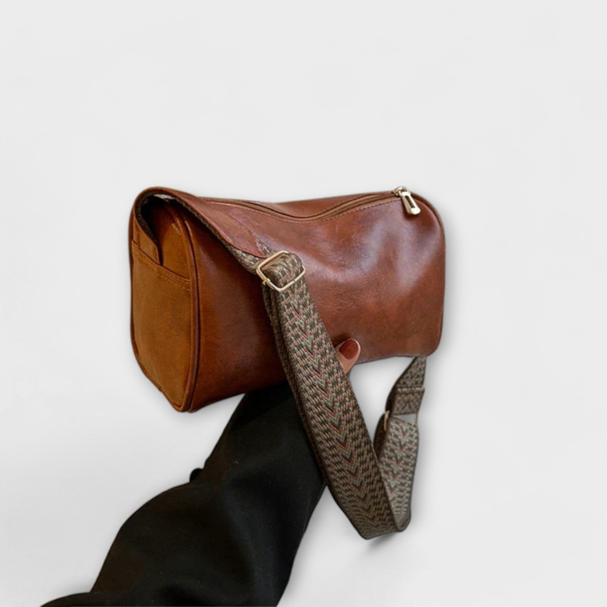 Beige woven shoulder bag with wide braided strap, spacious cylindrical shape for modern urban style