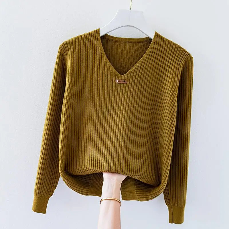 Ivory slim-fit ribbed knit pullover top with V-neckline and metal charm collar accent