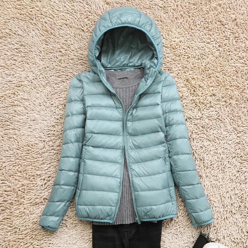 Women's quilted down jacket tailored hip-length fit with hood, lightweight warmth in neutral tone