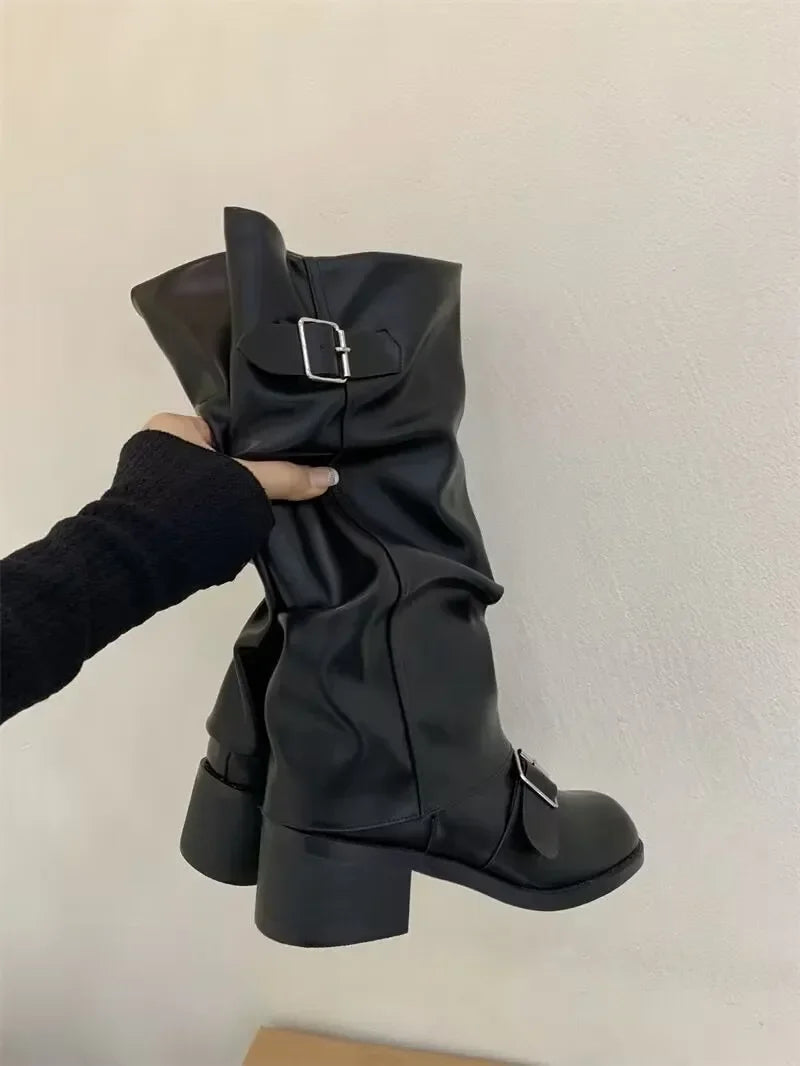 Black knee-high platform boots with chunky heels and moto-inspired gothic style for bold fall looks