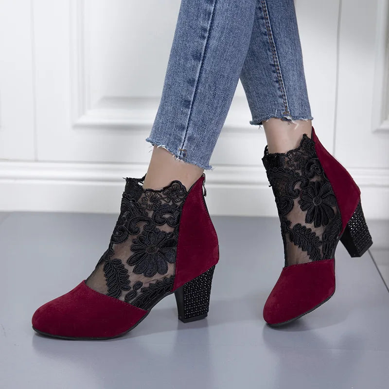 Black lacy mesh high heel boots with delicate floral cutout design and stiletto heel