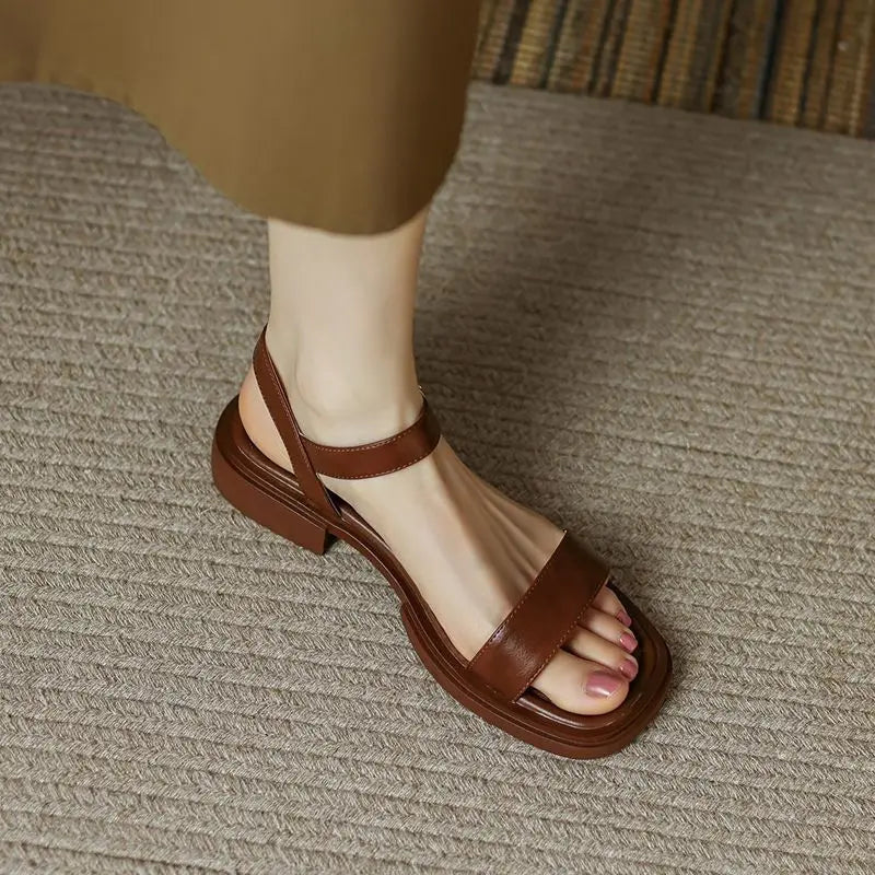 Women's slip-on sandals in neutral tone with cushioned sole and minimalist buckle accent detail