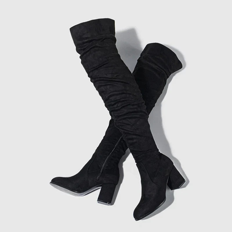 Black over-the-knee women's heeled boots with block heel and sleek elongating silhouette