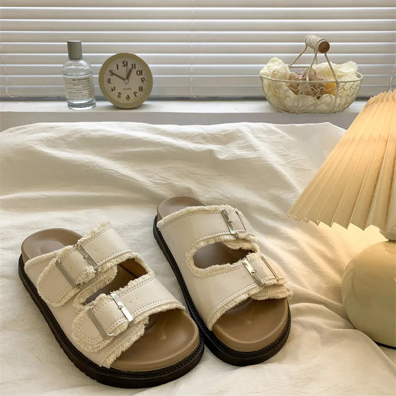 Women's cushioned slip-on buckle sandals in neutral tones with contoured footbed and stylish accent