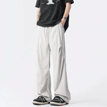 Neutral tufted parachute pants wide-leg relaxed fit with chrome-tip drawstrings and crinkled nylon fabric