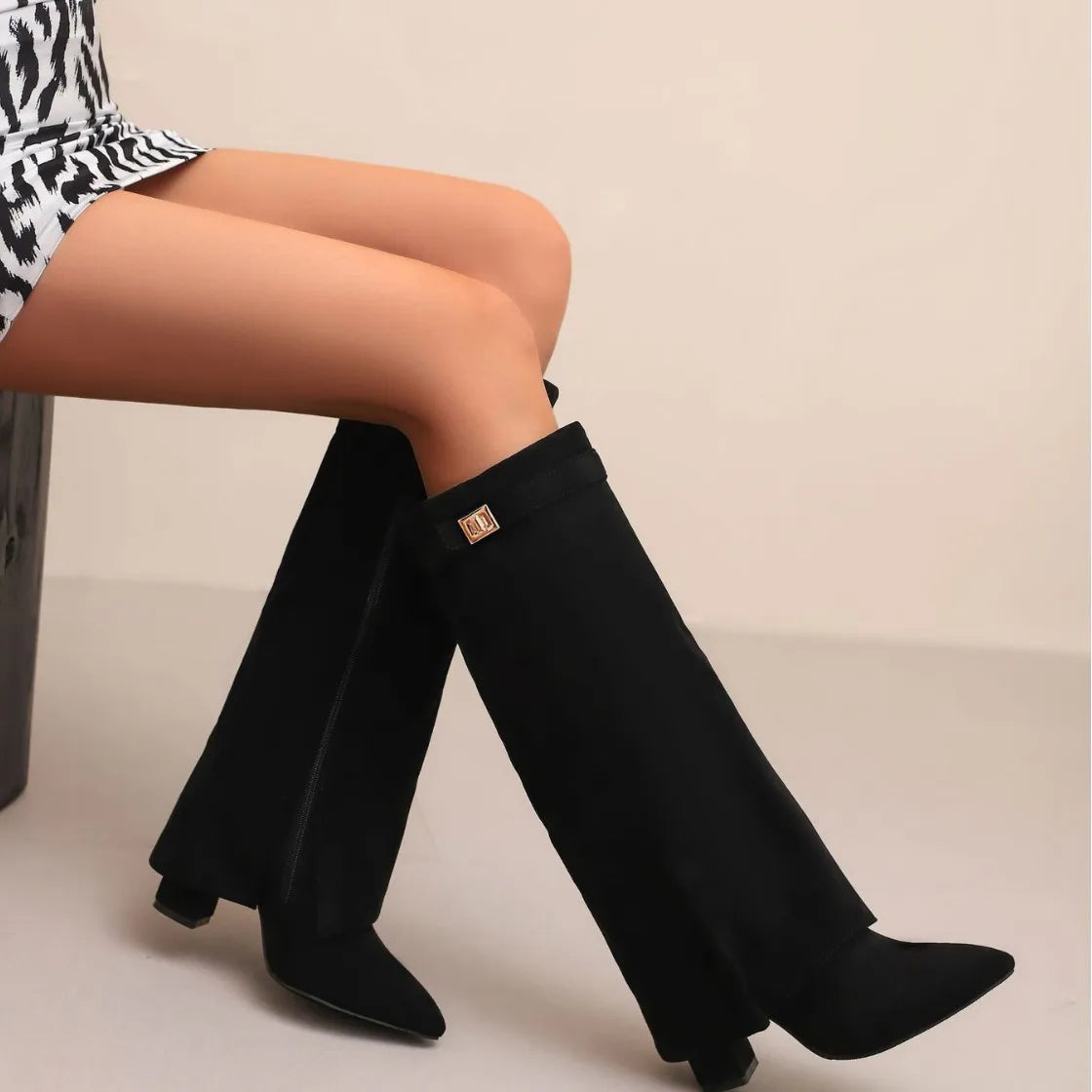 Women's black leather thigh-high boots with bold buckle detail, sleek fitted silhouette