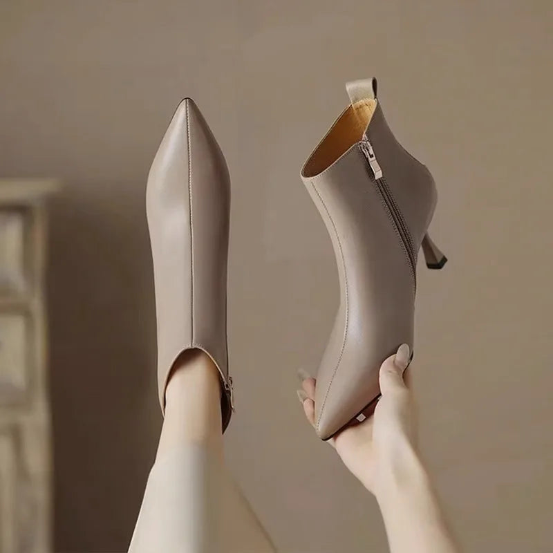Black pointed-toe kitten heel boots with slender stiletto heel and sleek luxe finish
